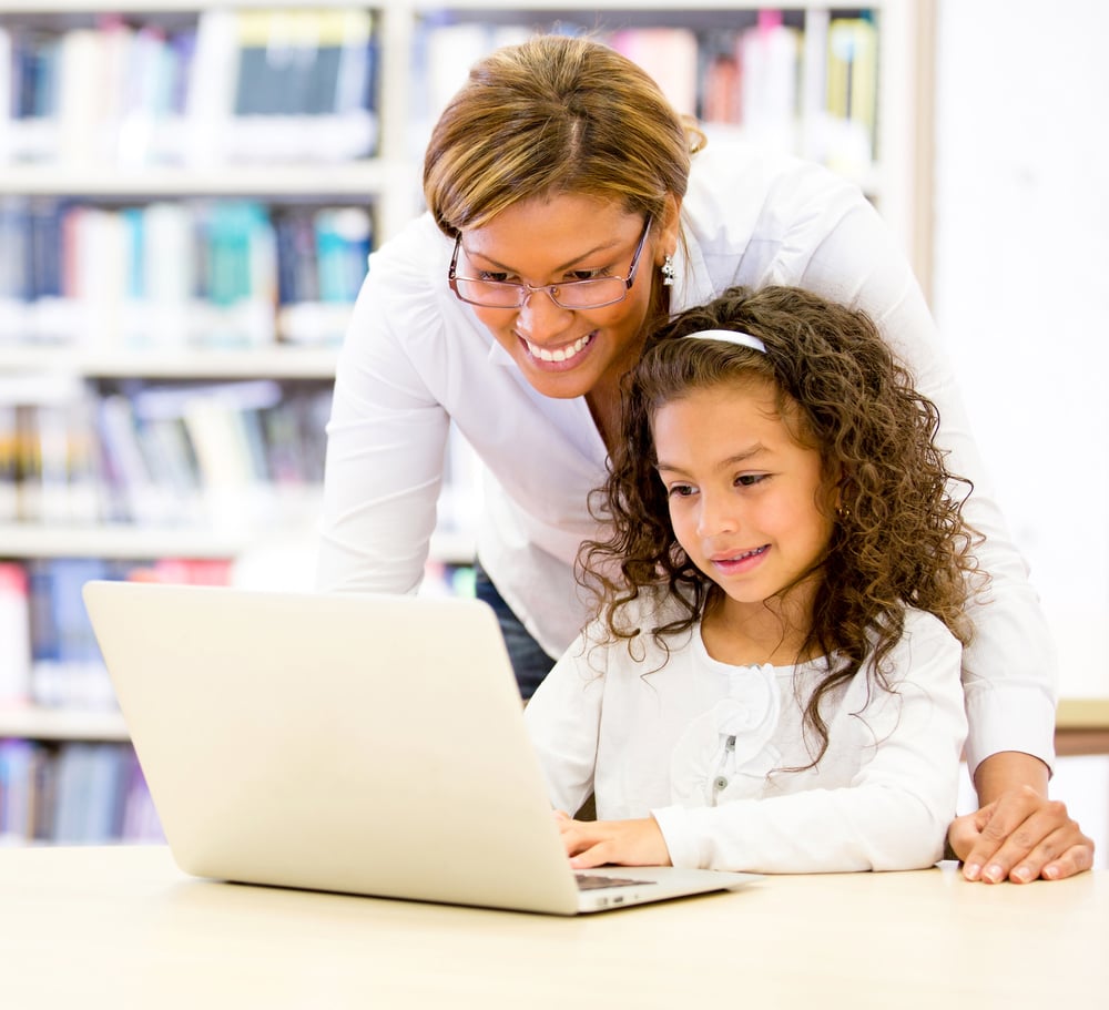 ICT teacher with a young student using the computer